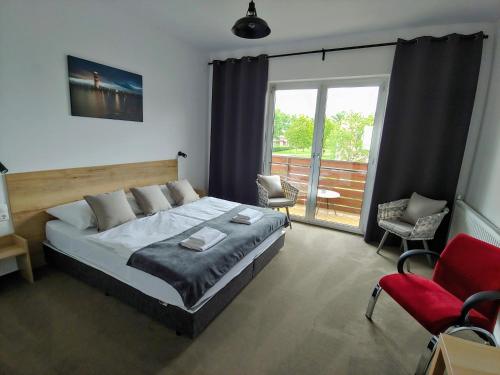a bedroom with a large bed and two chairs at PROMENADE in Podersdorf am See