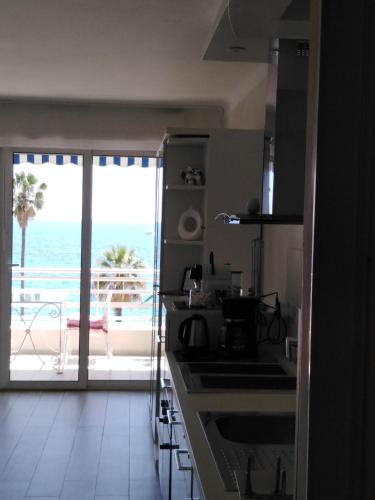 une cuisine avec vue sur l'océan dans l'établissement Le Palais du Tropique appartement vue mer 5é étage avec ascenseur, à Juan-les-Pins