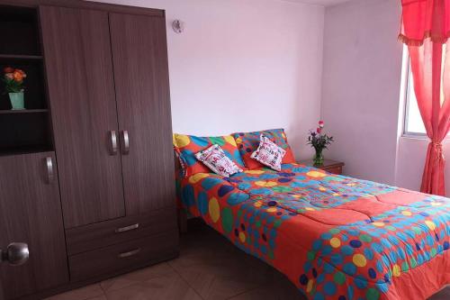 a bedroom with a bed with a colorful comforter at Apartamento en Bogotá muy bien ubicado cerca al aeropuerto in Bogotá