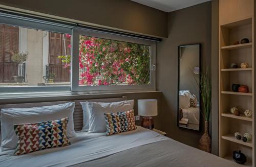 a bedroom with a window and a bed with pillows at Azur by Stylish Stays in Athens