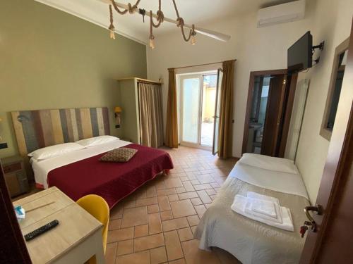 a hotel room with two beds and a table and a desk at Camere Frangimare in Porto Recanati