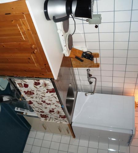 a kitchen with a sink and a white tiled floor at Eriks Bädd och Pentry in Hillerstorp