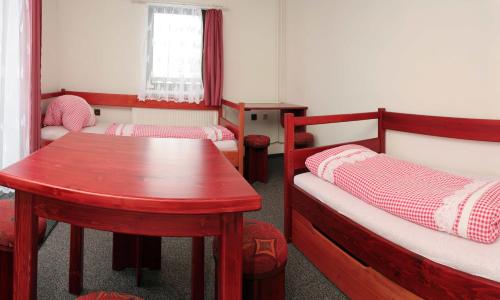 a small room with two beds and a table at Ubytování Karolinka in Prášily