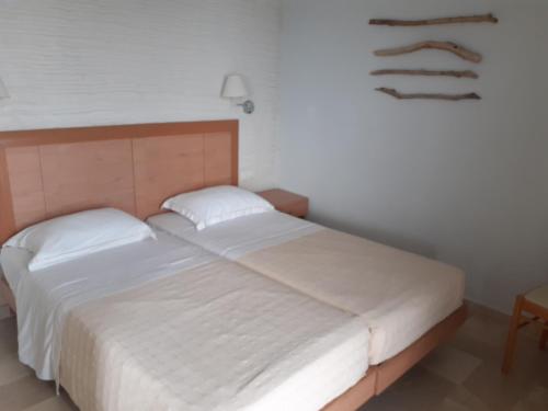 sypialnia z białym łóżkiem z drewnianym zagłówkiem w obiekcie Superior Suite Cronus w mieście Vassilias