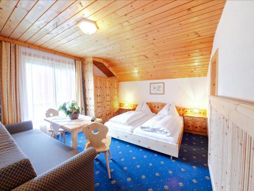 a hotel room with a bed and a table at Sagritzerwirt in Großkirchheim
