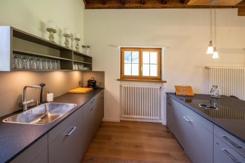 uma grande cozinha com um lavatório e uma janela em Chalet Laret em Davos