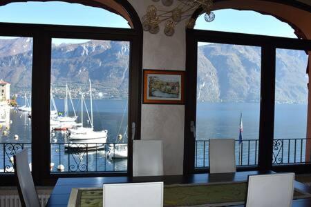 a dining room with a view of a marina with boats at BELLAGIO LAKESIDE APARTMENT in Bellagio