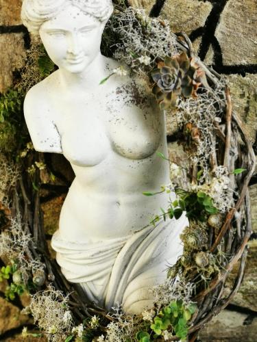 a statue of a woman with flowers on a wall at Das Stadthaus in Neusiedl am See