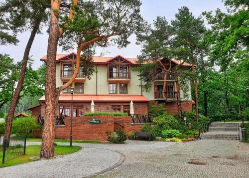 a large brick house with trees in front of it at Stacja Nowa Gdynia Bed & Breakfast Aquapark in Łódź