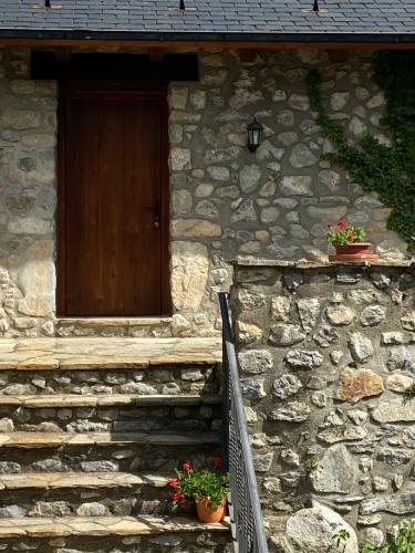 a stone building with a wooden door and some plants at Casa Sansón in Chía