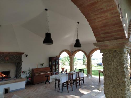 ein Esszimmer mit einem Tisch, Stühlen und einem Kamin in der Unterkunft Marrucheto in Giuncarico