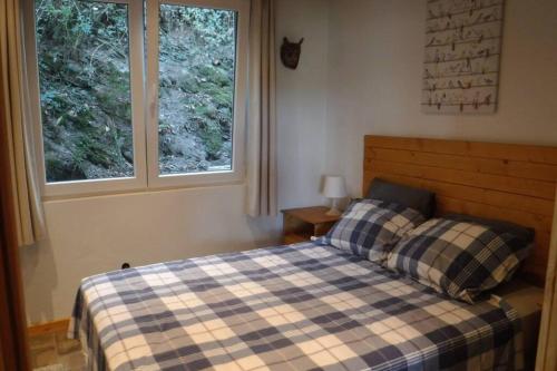 a bedroom with a bed and two windows at The Vianden Cottage - Charming Cottage in the Forest in Vianden