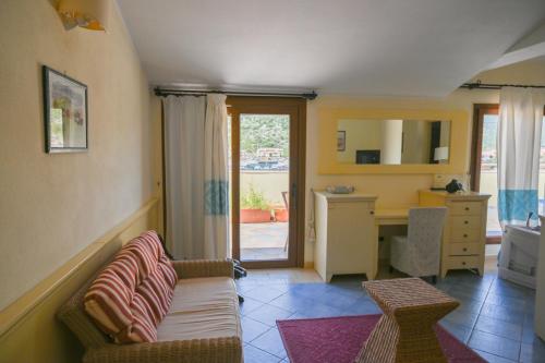 Il comprend un salon avec un canapé et une cuisine avec un bureau. dans l'établissement Hotel Baja Romantica, à Bosa