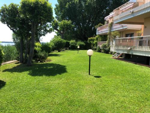 a yard with green grass and a building at Lake Front Luxury Apartment in Sirmione