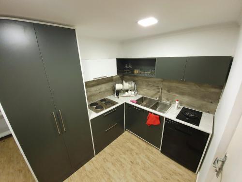 a small kitchen with gray cabinets and a sink at Nino Ratiani's Guesthouse in Mestia