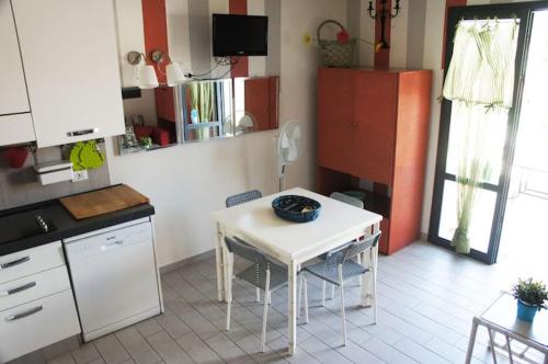 a kitchen with a small white table and chairs at Nicola's Apartments in Marina di Campo