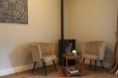 a room with two chairs and a table with a candle at Bosgeluk in Helmond