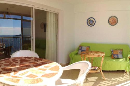 un soggiorno con divano verde e tavolo di Apartamento en Playa de Levante Vistas impresionantes a Benidorm