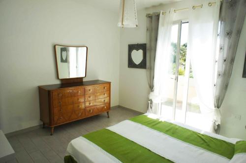 a bedroom with a bed and a mirror and a dresser at Nicola's Apartments in Marina di Campo