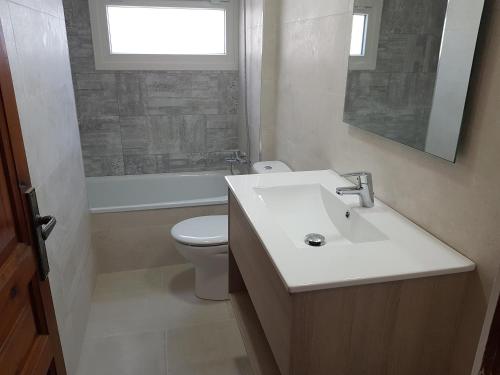 a bathroom with a sink and a toilet and a window at E-2 CALELLA DE PALAFRUGELL 8 PAX in Calella de Palafrugell