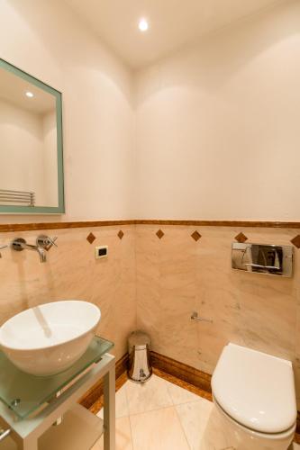 a bathroom with a white sink and a toilet at Lake Front Luxury Apartment in Sirmione