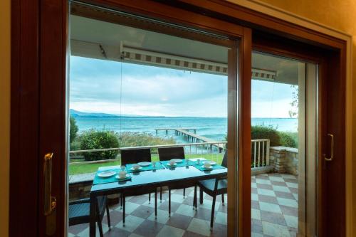 a dining room with a table and a large window at Lake Front Luxury Apartment in Sirmione