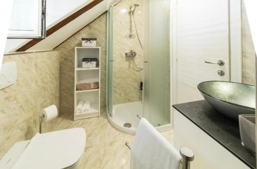 ein Bad mit einem Waschbecken und einer Glasdusche in der Unterkunft Apartman Roseta in Dubrovnik