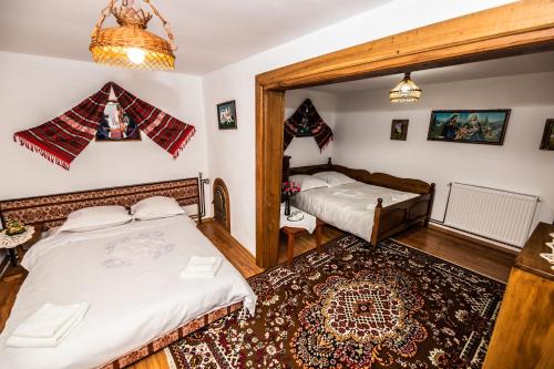 a bedroom with two twin beds and a rug at Casa de sub deal in Bîltişoara