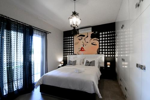 villa elena في بريفيزا: غرفة نوم بسرير مع لوحة على الحائط