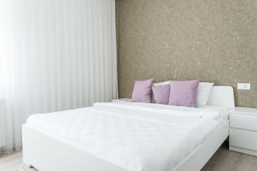 a bedroom with two white beds with purple pillows at Hotel MOREA in Ljubljana