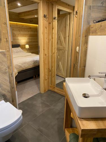 łazienka z umywalką, toaletą i łóżkiem w obiekcie willa ella w Zakopanem