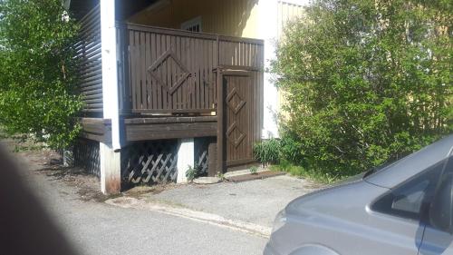 una puerta de madera a una casa con un coche aparcado al lado en Asemantupa 1 en Pyhäsalmi