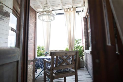 a chair on a porch with a table and a chandelier at Liegen;schaft Guesthouse in Oestrich-Winkel