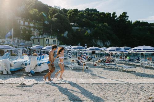 a man and a woman walking on the beach at NUMA HOTEL in Numana