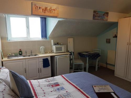 a small kitchen with a bed in a room at Cumbria Guest House in Lytham St Annes