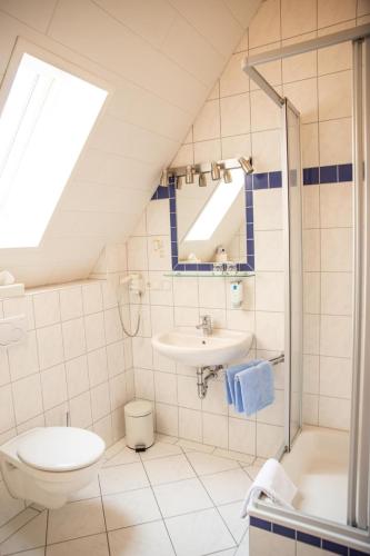 a white bathroom with a sink and a toilet at Ferienwohnung Wappenstube in Erbach