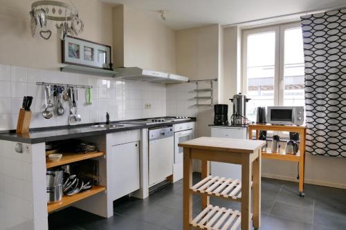 a kitchen with a sink and a stove top oven at De Oude School in Visé