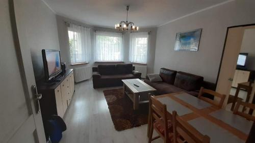 a living room with a couch and a tv at Apartament Kamień Pomorski in Kamień Pomorski
