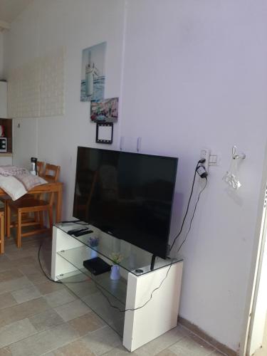 a flat screen tv sitting on top of a white entertainment center at comft suite Nahariyya in Nahariyya