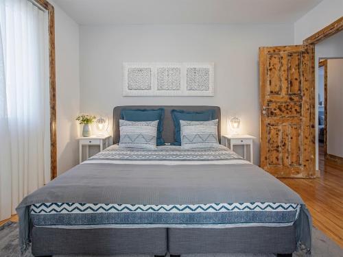 a bedroom with a large bed with blue head board at Je T'aime Porto Sweet Rooms in Vila Nova de Gaia