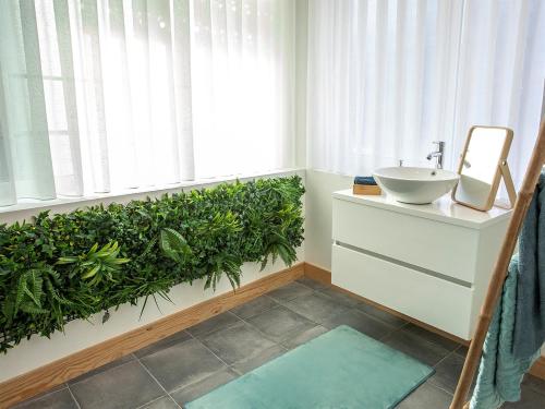 a bathroom with a sink and a green plant at Porto Je T'aime - Sweet Rooms in Vila Nova de Gaia