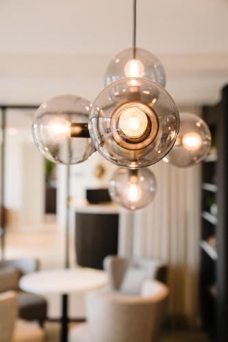 a chandelier with several lights in a room at Hotel du Bassin in Ostend