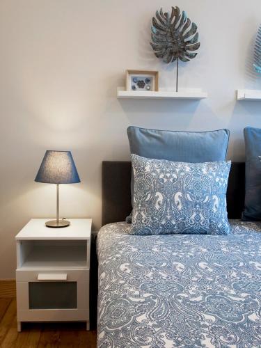 a bedroom with a bed and a nightstand with a lamp at Je T'aime Porto Sweet Rooms in Vila Nova de Gaia