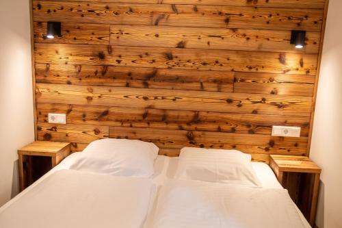 two beds in a room with a wooden wall at Apartment Michael - Zell am See - Kaprun in Piesendorf
