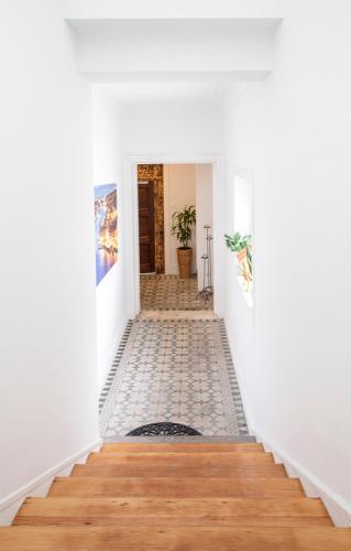 a hallway with white walls and a tile floor at Je T'aime Porto Sweet Rooms in Vila Nova de Gaia