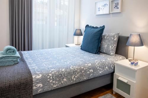 a bedroom with a bed and two lamps and a window at Je T'aime Porto Sweet Rooms in Vila Nova de Gaia