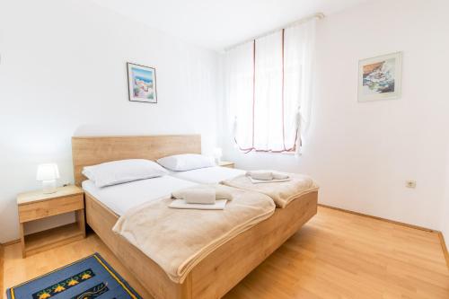 a bedroom with a large bed and a window at Apartman Lana in Baška