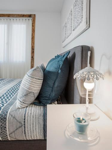 a living room with a bed and a table with a lamp at Je T'aime Porto Sweet Rooms in Vila Nova de Gaia