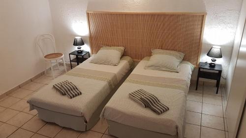 two beds in a room with two tables and two lamps at Entre Mer et Estérel in Roquebrune-sur-Argens