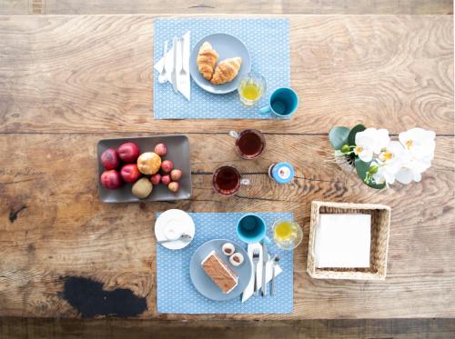 a table with a plate of food and glasses of wine at Je T'aime Porto Sweet Rooms in Vila Nova de Gaia